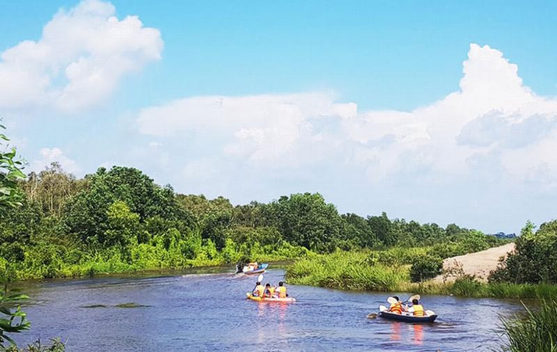 Hình ảnh du khách tham gia hoạt động du lịch sinh thái khám phá tài nguyên du lịch vùng Đông Nam Bộ, như đi bộ trong rừng hoặc đi thuyền qua khu rừng ngập mặn